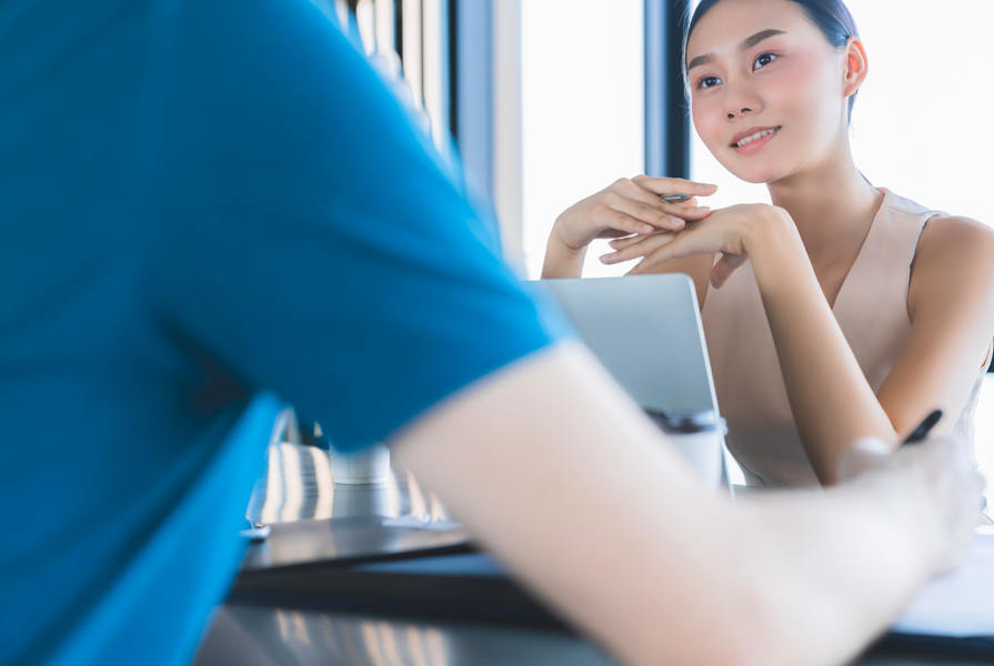 微笑的女性在診間聆聽醫師說明，象徵柔滴隆乳術後追蹤回診