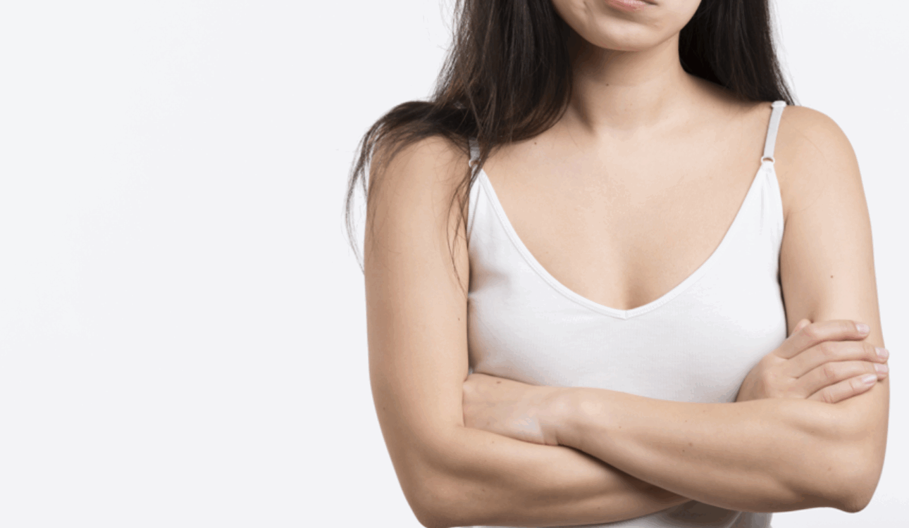 一位女性雙手輕輕按在畫有虛線標記的胸部上，背景模糊為藍色和白色