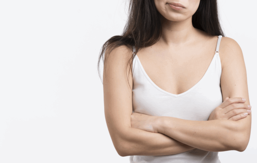 一位女性雙手輕輕按在畫有虛線標記的胸部上，背景模糊為藍色和白色