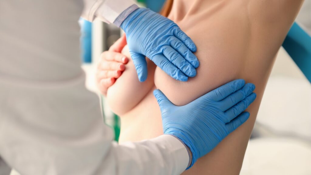 醫師配戴藍色手套，透過觸診評估患者隆乳術後的空間感與組織柔軟度，進行專業的醫療檢查