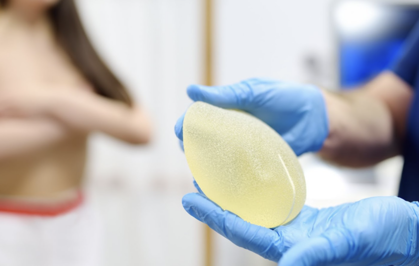 醫護人員雙手展示一個圓盤狀的毛面矽膠隆乳假體，清晰呈現植體的高凝聚力質地