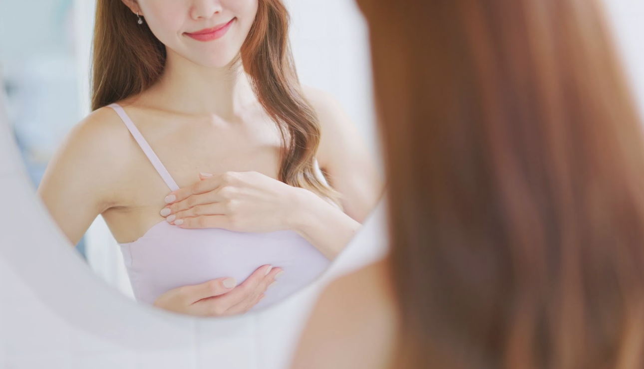 術後女性在鏡前檢查胸部形態展現自信微笑