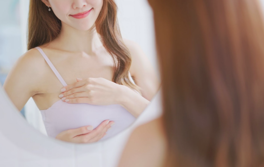 術後女性在鏡前檢查胸部形態展現自信微笑