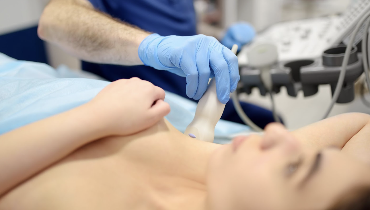 醫療人員使用超音波掃描儀對女性患者的胸部進行檢查，確保組織健康或監測植入物狀態，畫面呈現專業醫療診斷流程