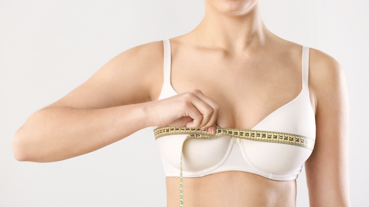 女性穿著白色內衣使用布尺測量胸圍大小