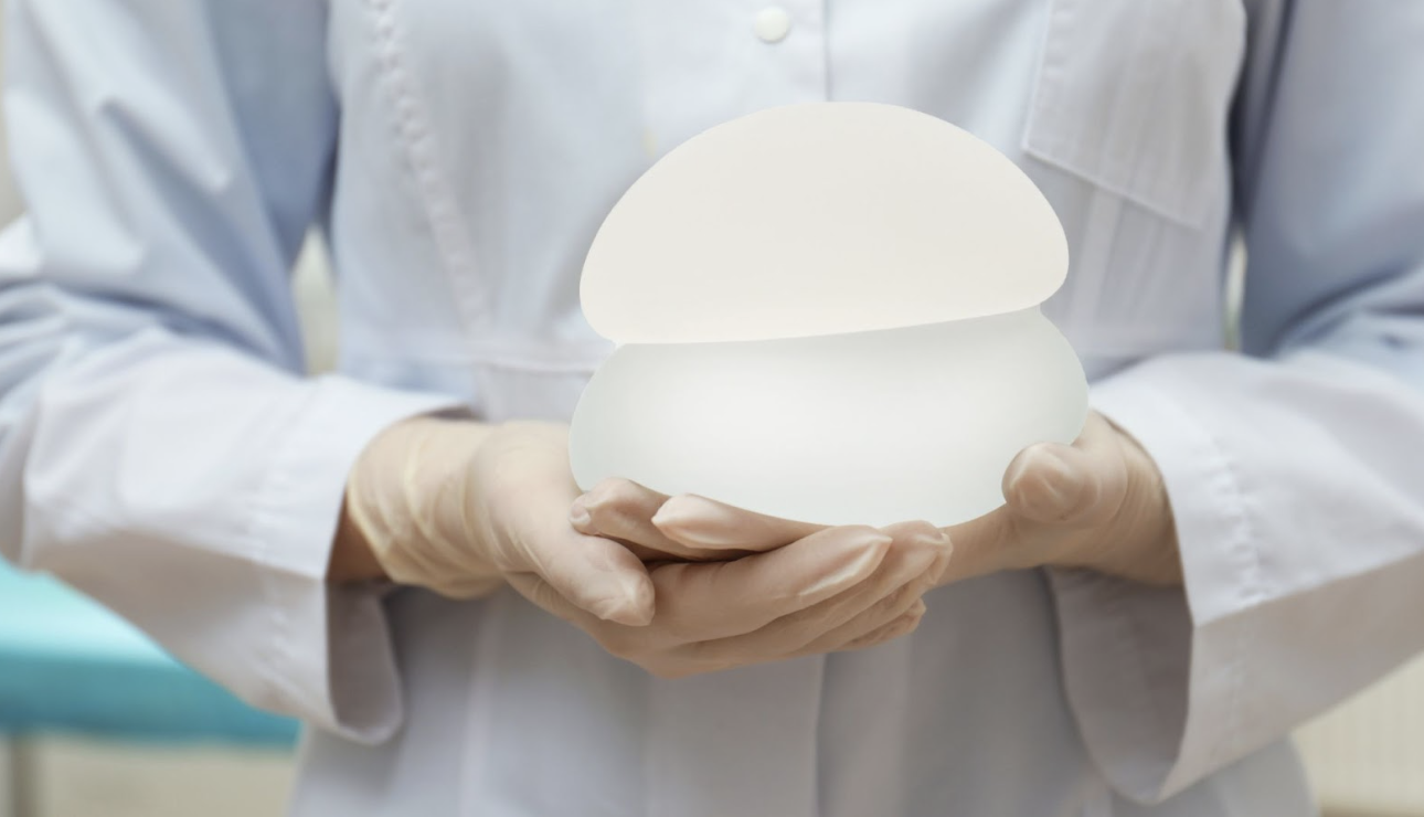 醫護人員雙手持握兩款不同形狀與大小的霧面矽膠義乳模型