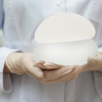 醫護人員雙手持握兩款不同形狀與大小的霧面矽膠義乳模型