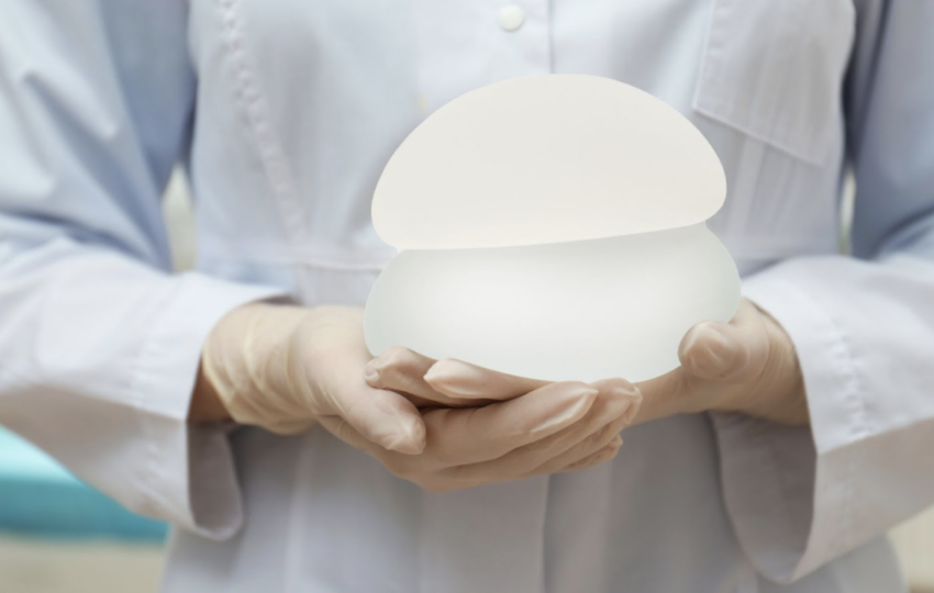 醫護人員雙手持握兩款不同形狀與大小的霧面矽膠義乳模型